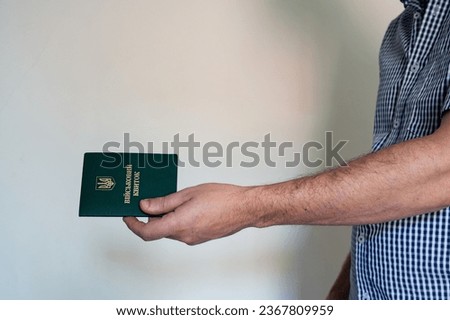 Translation: "military id". Civil man in shirt with army document for rookie, veteran, soldier in hand on white background