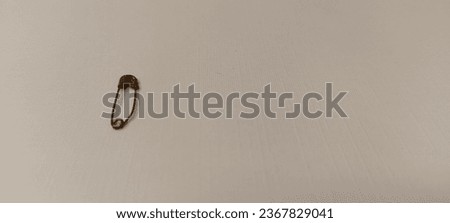 Jakarta, September 28 2023, 13.05. one small silver safety pin. with white as the background. photo taken from the top side angle. 