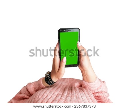 female hands hold a smartphone, green screen , woman with a pink manicure in a pink sweater and in a watch holds a smartphone, use of social media