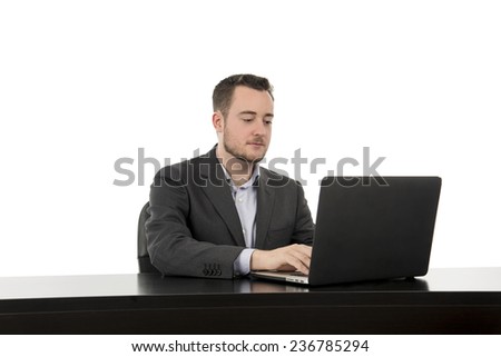 Concentrated business man working hard on laptop against a white background