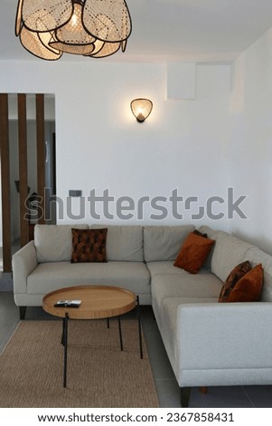 Spacious living room with stockholm nesting tables and corner sofa and a bunch of colorful pillows on it. Copy space for text. background.