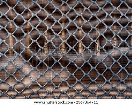 Metal grid background. horizontal diamond-shaped gray metal mesh with beige metal rods in the background