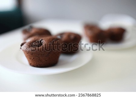 Close-up of tasty dessert for tea or coffee. Chocolate brownies with cocoa stuffing on white plate. Homemade cupcakes with crispy top. Bakery and confectionery concept