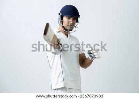 Indian cricketer lifting cricket bat towards the camera and celebrating his century, cricket concept Royalty-Free Stock Photo #2367873983