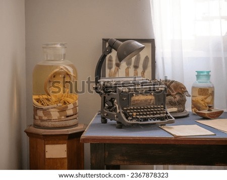 vintage office of zoologist explorer scientist with retro typewriter and cobra snake and other animals in a jar of formalin