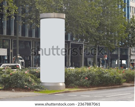 Empty advertising pillar in a city with grey free copy space, promotion mock up. Blank advertising panel in a city
