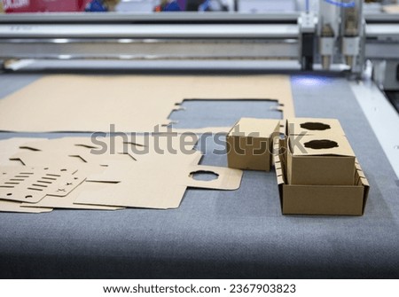 Digital die cut machine cutting corrugated cardboard products. Industrial manufacture. Royalty-Free Stock Photo #2367903823