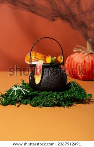 Trick or treat. Witchs cauldron with various creepy sweets stands on moss