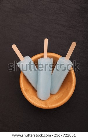 Blue popsicles in wooden bowl 