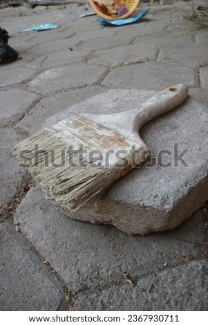 paint brush lying on a stone with a brick background