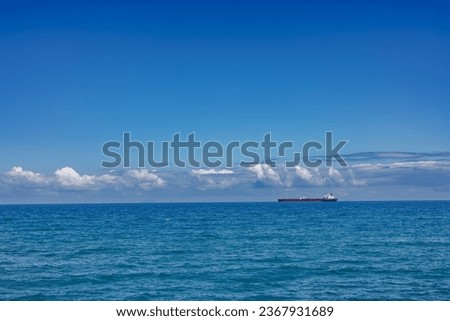 Cargo ship on the horizon off the coast of Sicily, Italy