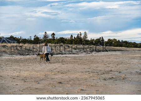 Happy woman on the beach with a dog in Maine, America
