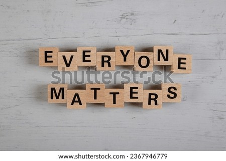 wooden blocks  in a white and grey board with the text everyone matters Royalty-Free Stock Photo #2367946779