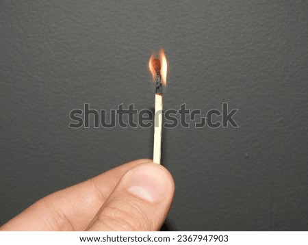 Hand holding a lit match fire macro picture closeup