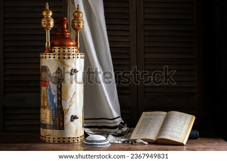 Torah scroll with prayer shawl tallit and kippah on a dark background Royalty-Free Stock Photo #2367949831