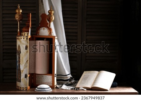 Torah scroll with prayer shawl tallit and kippah on a dark background Royalty-Free Stock Photo #2367949837