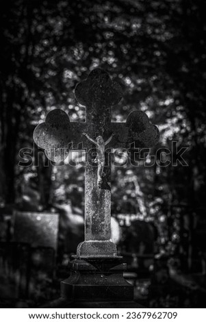 CEMETERY - An old crucifix with a figurine of Jesus on a tombstone