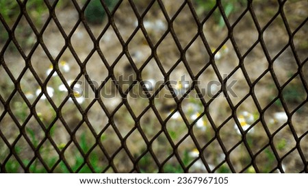 background of woven iron crisscrossed with blurry flowers
