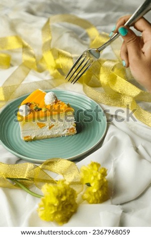 Mango Yogurt Cake slice topping with pistachio fork and flowers served in plate isolated on napkin side view cafe bake food