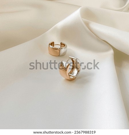 Stylish earrings in 14k pink gold on plaster mold. Royalty-Free Stock Photo #2367988319