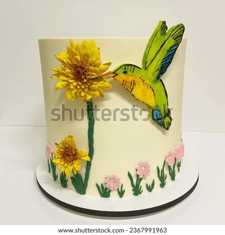 Birthday cake decorated with hummingbirds and flowers. Isolated on a white background. Front view.