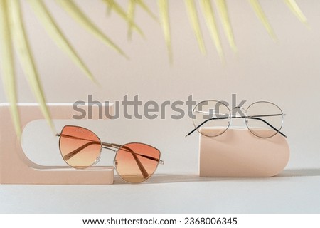 Sunglasses and glasses sale concept. Glamour sunglasses on podiums on beige background with golden palm leaves. Trendy Fashion summer accessories. Eyewear sale promotion. Optic store discount poster Royalty-Free Stock Photo #2368006345
