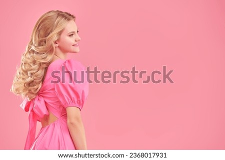 A beautiful gentle girl with delightful blond wavy hair smiles. Profile portrait. Pink studio background with copy space. Beauty, cosmetics. Hair Styling.