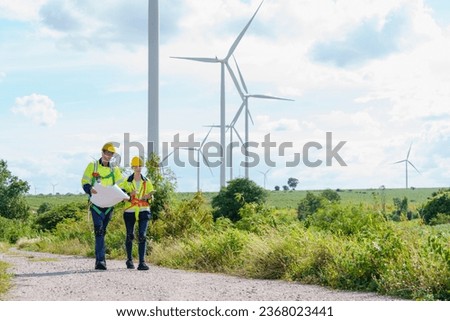 Architectural Engineering Caucasian working and maintenance with wind turbine blueprint pictures of wind turbines at windmill field farm. Alternative renewable energy for better living concept. 