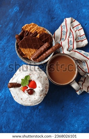 Cup of tea with milk, waffles and cookie, whipped cream cake on a table. Top view photo. English tea concept.