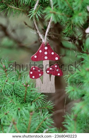 Wooden Christmas decoration on a green fir tree. Close up photo of an eco friendly handmade Christmas ornament. 