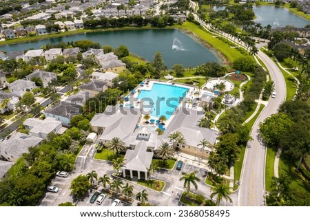 Aerial drone photoshoot Footage in Florida, USA, commercial area, luxury houses, buildings and mansions, abundant tropical vegetation around, blue sky and water canal with boats.