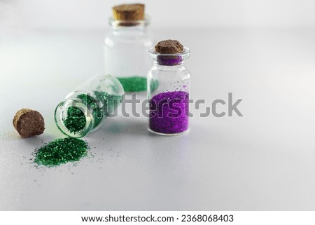 Glitter bottles isolated on white background with copy space. Concept of glitter sales ban in Europe for environmental protection.