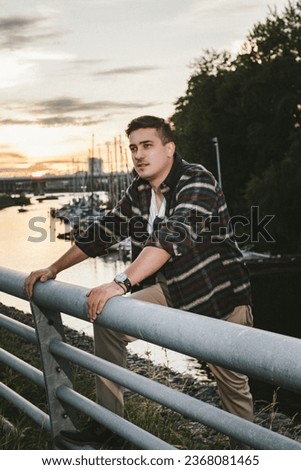 man caucasian model millionaire yachtsman in a shirt with a watch on his wrist, stands on the pier of the yacht club at sunset Royalty-Free Stock Photo #2368081465