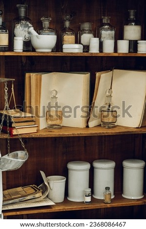 Picture of vintage objects on a shelf. Lab equipment, books, jars, and vessels on a shelf in a vintage drugstore. Royalty-Free Stock Photo #2368086467