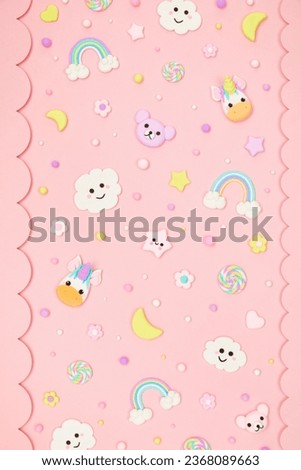 Trendy pastel pink kawaii background with decorative paper borders and cute air plasticine handmade cartoon animals, unicorns, stars, rainbows pattern. Top view, flat lay. Candycore, fairycore.