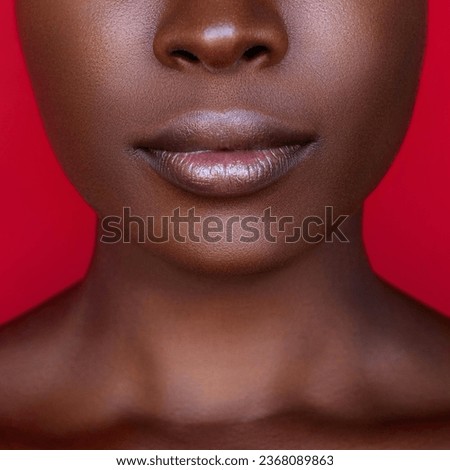 Close up cropped portrait of fashion African American model with a clean smooth skin and big lips isolated on red background 