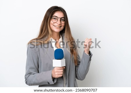 Young caucasian TV presenter woman isolated on white background pointing to the side to present a product Royalty-Free Stock Photo #2368090707
