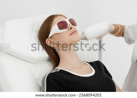 Young woman having laser hair removal procedure of chin zone by specialist in cosmetic center. Removes pigmentation in cosmetic clinic. Intensive Pulsed Light Therapy. Anti-aging treatments. Royalty-Free Stock Photo #2368094201