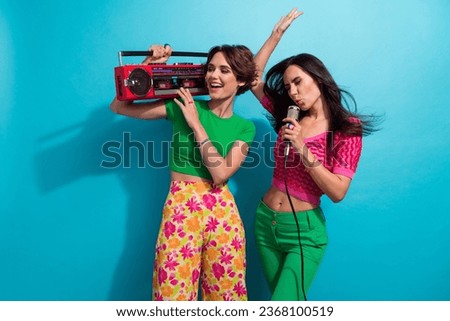 Photo of cheerful cute girls dressed colorful outfits singing mic listening boom box isolated blue color background