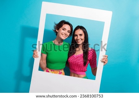 Photo of shiny cheerful girls dressed colorful outfits tacking photo portrait together isolated blue color background
