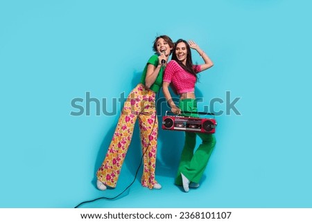Full length cadre of careless two girls bachelorette together sing karaoke studio take boombox look mockup isolated on blue color background