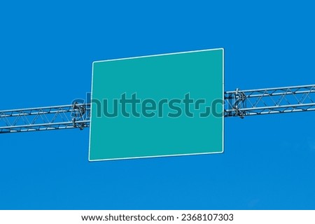 Road sign. Empty copy space above direction board. Metal frame over the road. Isolated on blue sky.