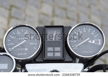 Dashboard of a vintage motorcycle. Visible: speedometer, tachometer and odometer.Chrome gauges ("clocks") on the handlebar of a vintage motorcycle in the "good old style".