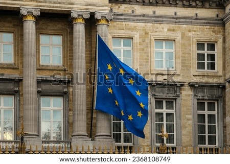EU flag proudly displayed against an administive building in the heart of Brussels. This image symbolizes European unity and governance, reflecting the political center of euro integration. Royalty-Free Stock Photo #2368108749
