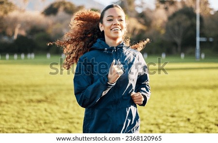 Fitness field, happy and woman running for outdoor exercise, cardio workout or training for marathon race. Sports warm up, athlete smile and morning runner doing exercise challenge on grass pitch Royalty-Free Stock Photo #2368120965