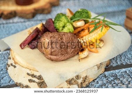 Delicious filet mignon steak with grilled vegetables.Steak filet minion, bbq steak  beef. On a wooden stump and a wooden background