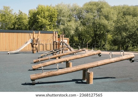 Wooden playground made of natural eco-friendly material in public city park. Modern safety children outdoor equipment. Concept of sustainable lifestyle and ecology. Children rest and games on open air