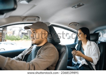 Young asian woman traveler talking with taxi driver explain the route how to travel in direction destination. Passenger showing the direction to taxi driver travel in city. Driver application service Royalty-Free Stock Photo #2368139891