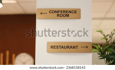 Close up of directions signs to restaurant, conference room and spa center amenities. Hotel facilities signs on travel vacation accommodation resort lounge wall, jib up shot Royalty-Free Stock Photo #2368158143