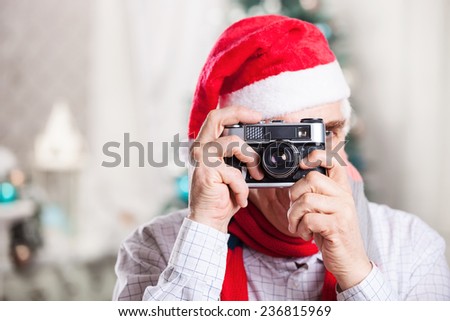 Senior man taking photo on Christmas background 